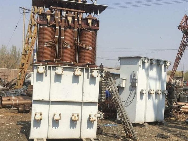 An old, weathered transformer still in service next to a newly installed one